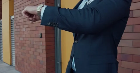 A young and model man, elegantly and expensively dressed, looks at his watch Video stock 138586684