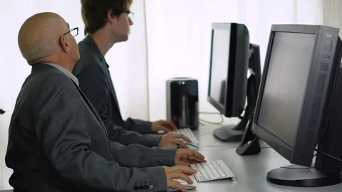 Young and Old Co-Worker Trying To Solve Problem With Computer in Office Stock Footage 113274810