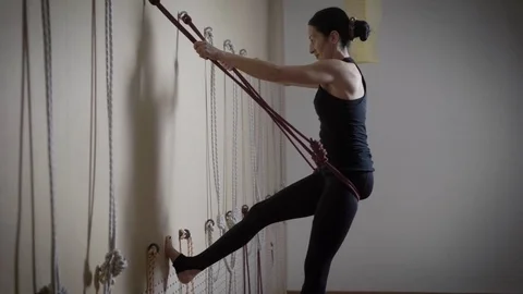 A young and pretty lady performs an inverted asana using ropes, a lady engaged Stock Footage 83166665