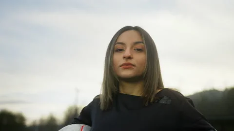 Young and strong soccer player woman looking at camera with soccer ball on ar Stock Footage 149406906