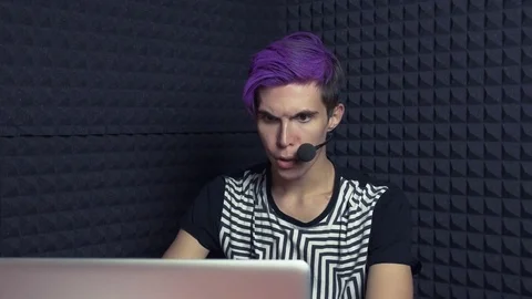 Young angry man with purple bangs taking video game blog in web studio Stock Footage 70803520