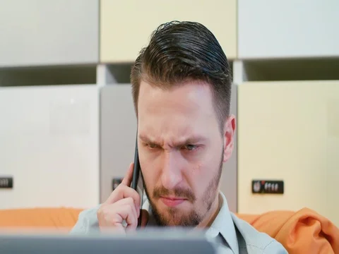 A Young Angry Man Talking on the Mobile Indoors Stock Footage 84772856