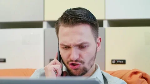 A Young Angry Man Talking on the Mobile Indoors Stock Footage 84773426