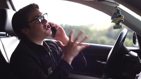 Young angry man talking by mobile phone inside his car,bulging eyes, moving hand 스톡 동영상 253825790