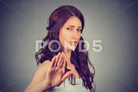 Young annoyed angry woman with bad attitude giving talk to hand gesture Stock Photos