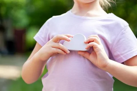 Young anonymous child, elementary school age girl holding a simple white clou Stock Photos