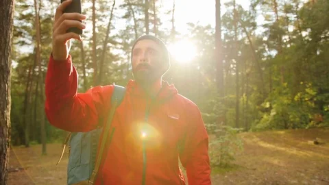 Young appealing man hikers looking for the mobile connection in the forest on a Stock Footage 82808852