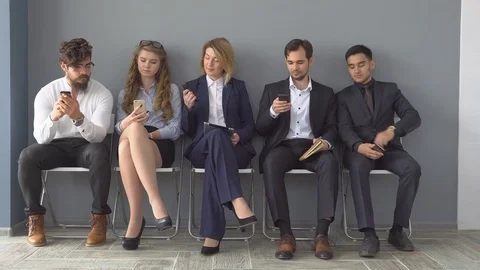 Young applicants are awaiting interview. a group of young people bored waiting Stock Footage 76202218