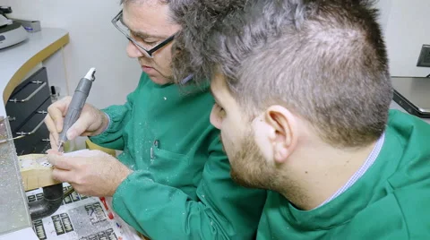 Young apprentice flanking a senior technician in a prosthodontics laboratory Stock Footage 59940182