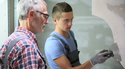 Young apprentice with professional plasterer Stock Footage 51559889