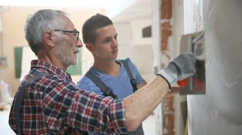 Young apprentice with professional plasterer Stock Footage 51560121