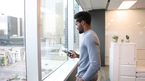 Young apprentice talking on phone beside glass wall Video stock 221032420