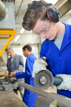Young apprentice using a metal cutter Stock Photos