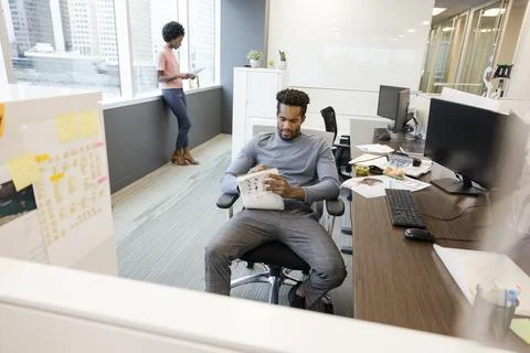 Young apprentice writing on book at desk in coworking space Stock Photos