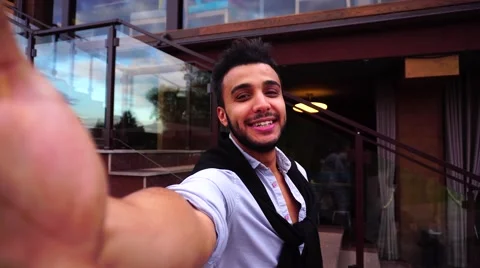 Young Arab Guy Takes Selfie With Camera Hand, Looking at Camera and Smiling on Stock Footage 68681917