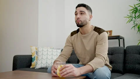 Young arab man having breakfast sitting on sofa at home Video stock 233419112