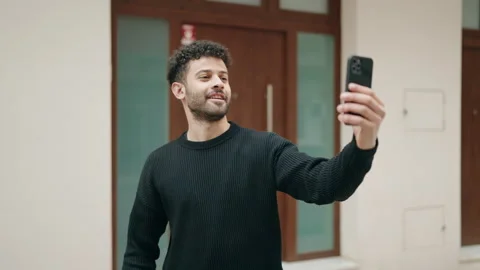 Young arab man having video call holding key of new home at street Video stock 173797294
