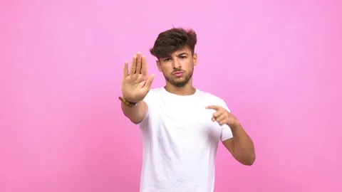 Young arab man serious and determined, putting hand in front, stop gesture, deny Stock Footage 138664166