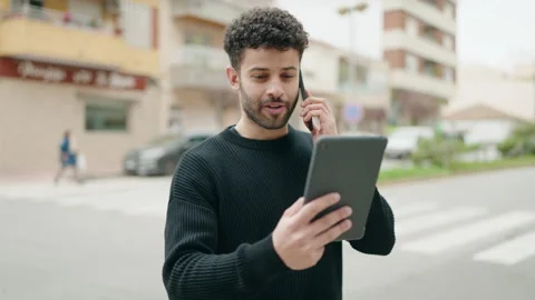 Young arab man talking on the smartphone using touchpad at street Video stock 173796652