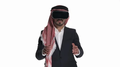 Young Arab man in virtual reality glasses imitating car driving, looking to the Stock Footage 125831488