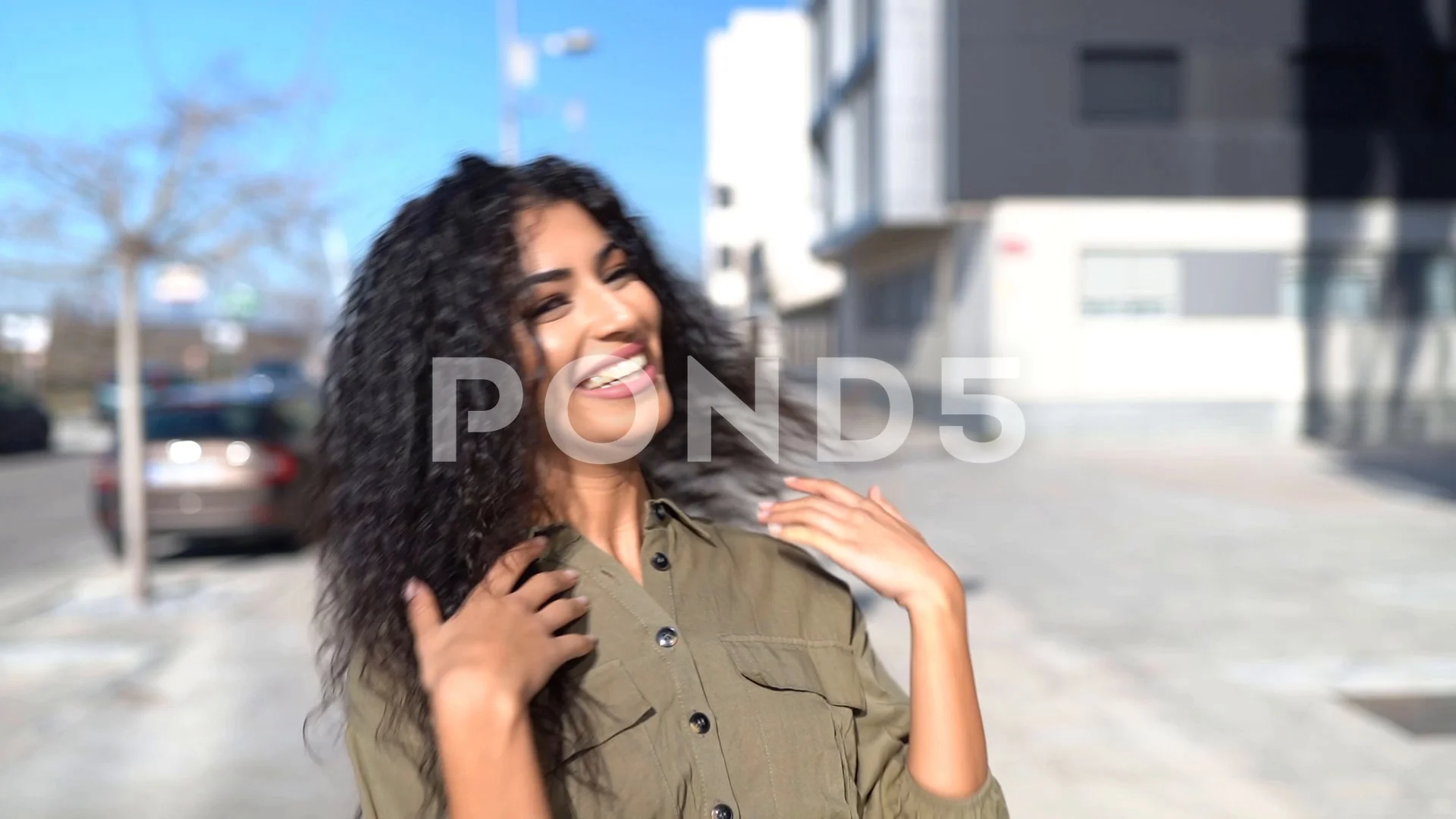 Young Arab woman moving her black curly hair