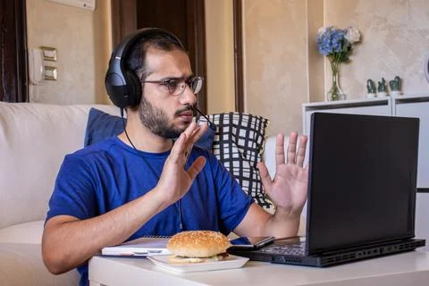 Young arabic man eating while working and  at home Stock Photos