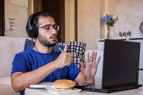 Young arabic man eating while working and  at home Stock Photos