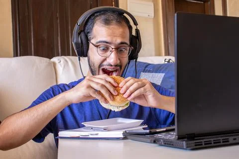 Young arabic man eating while working and  at home Stock Photos