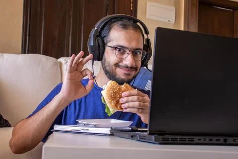 Young arabic man eating while working and  at home Stock Photos