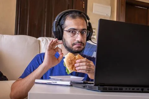 Young arabic man eating while working and  at home Stock Photos