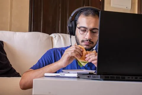 Young arabic man eating while working and  at home Stock Photos
