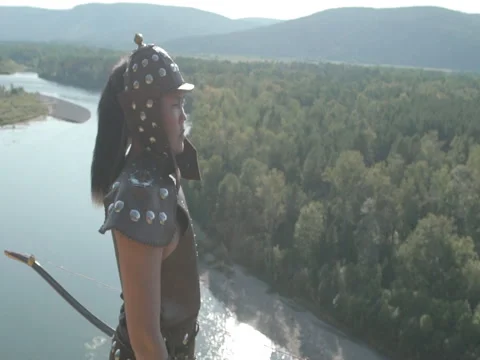 Young archer stands on high mountain on sunny day. Video stock 82371522