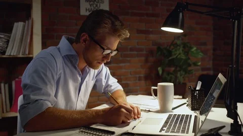 Young architect with blue shirt and light beard drawing with pencil and triangle Stock Footage
