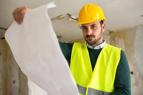 Young architect checking blueprint of  building reconstruction Stock Photos