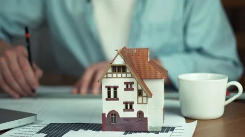 Young architect creating housing project, house model on table Stock Footage 81882035