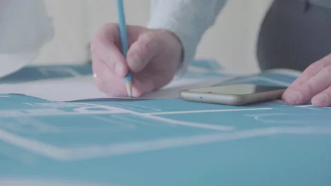 Young architect engineer working with blueprints laid out on a table Video stock 133055993