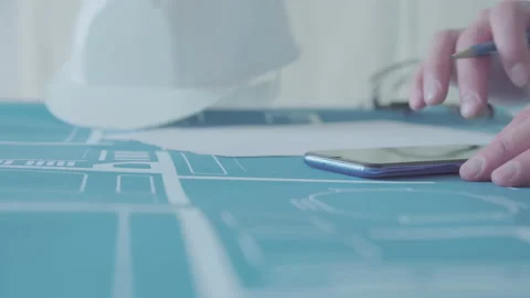 Young architect engineer working with blueprints laid out on a table Video stock 133056099