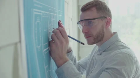 Young architect engineer works with blueprints  Video stock 133056513