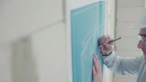 Young architect engineer works with blueprints  in a helmet and glasses Video stock 133056641