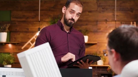 Young architect having a conversation with his colleague in the office Stock Footage 115072562