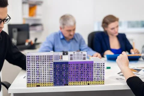 A young architect with his construction model on a meeting with Stock Photos