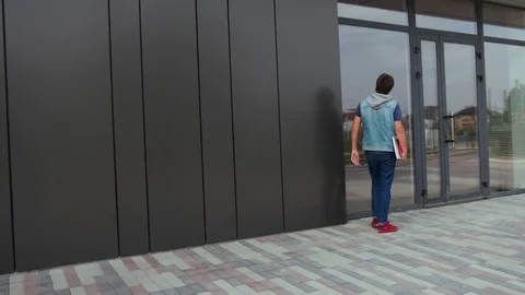 Young architect is looking on the new building with windows and alluminum panels Видео 82478883