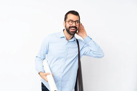 Young architect man with beard over isolated white background listening to so Stock Photos