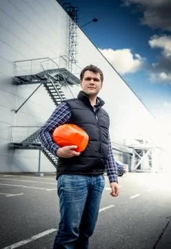 Young architect posing with hardhat against industrial building Stock Photos