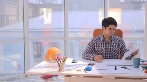Young architect working with blueprints in the office Stock Footage
