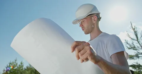 A young architect working in glasses and a fairy tale considers his project of Vídeos de archivo 142256057