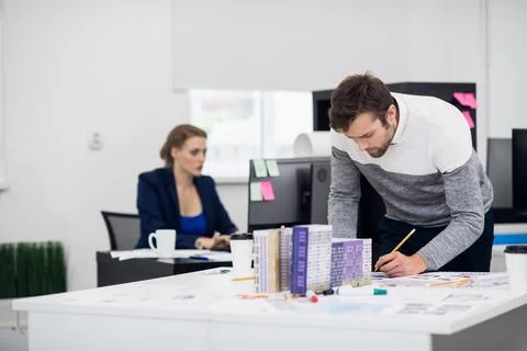Young architect working on his construction model in the bright Stock Photos