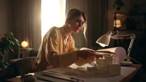 A young architect is working on a model of a house. Woman grinding a part after Stock Footage 273709615