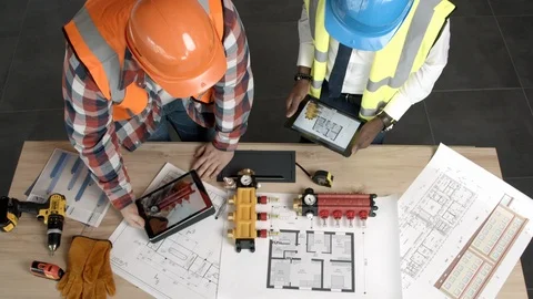 Young architects checking blueprints and equipment Stock Footage 125457904