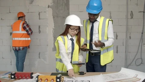 Young architects checking blueprints and equipment Stock Footage 125458231